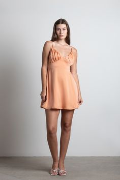 "The Heavenly Touch Satin Ruched Mini Skater Dress In Apricot Orange Is An Elegant Dress To Wear All Spring And Summer Long. This Skater Dress Features A Ruched Bust, Adjustable Straps, And A Side Zipper Closure. Pair With A Statement Necklace And Kitten Heels For A Contemporary Look To Wear During Brunch, Picnics, Or Summer Nights Out." Outfit For Bachelorette Party, Flowy Dress Short, Holiday Formal Dresses, Birthday Dress 21st, Bachelorette Party Dress, Apricot Orange, Bachelorette Party Outfit, Orange Satin, Mini Skater Dress