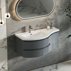 a bathroom sink sitting under a round mirror next to a wall mounted faucet