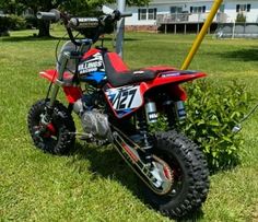 a red dirt bike parked in the grass