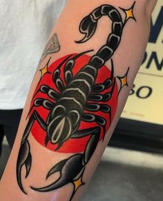 a tattoo on the arm of a man with a scorpion and stars around his neck