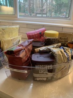 a plastic container filled with food sitting on top of a counter next to a window