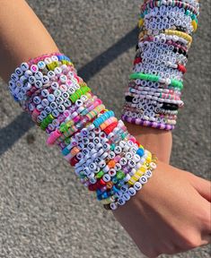 a person is holding several bracelets made out of letters on their arm and wrist