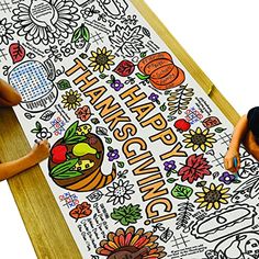 two children are sitting on the floor and looking at a large thanksgiving coloring page with turkeys