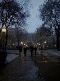 people walking down a sidewalk in the rain