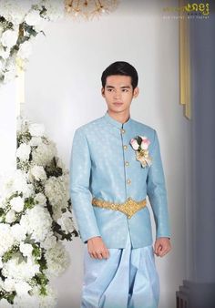 a man in a blue suit standing next to flowers