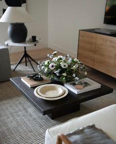 a coffee table with flowers on it in a living room