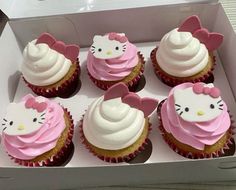 hello kitty cupcakes with pink frosting and white icing in a box