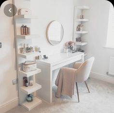 a white desk and chair in a room with shelving on the wall behind it