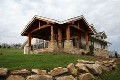 a large house sitting on top of a lush green field next to a stone wall