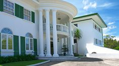 a large white house with green shutters on the front