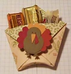 an origami turkey with candy in it's mouth