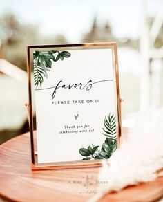 a close up of a sign on a wooden table with feathers in the foreground