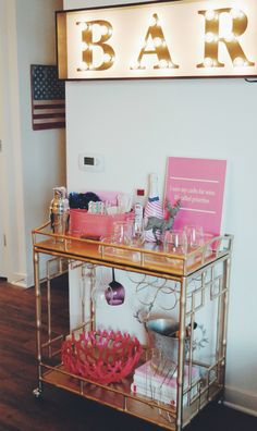 a bar cart with wine glasses and other items on it