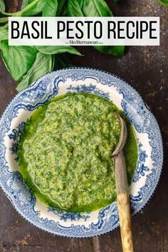 basil pesto in a blue and white bowl on a wooden table with basil leaves