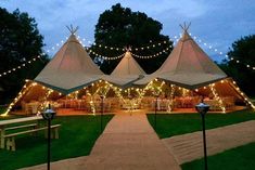 a large tent with lights on it and benches