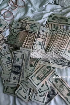 a pile of money sitting on top of a bed