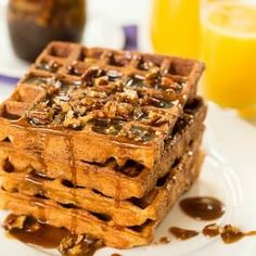 a stack of waffles sitting on top of a white plate covered in syrup