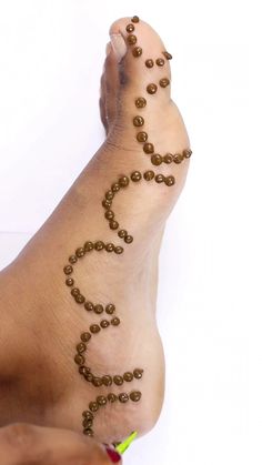 a woman's foot with beads on it and the bottom part of her leg