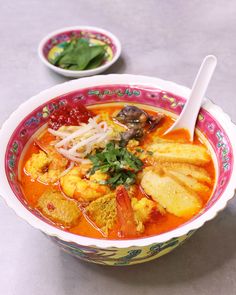 two bowls filled with soup and vegetables on top of a white countertop next to each other