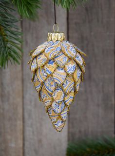 a blue and yellow ornament hanging from a tree