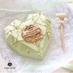 a heart shaped box with a name tag on it and some beads around the lid