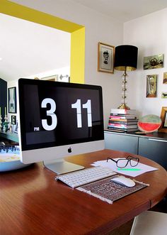 an apple computer sitting on top of a wooden desk