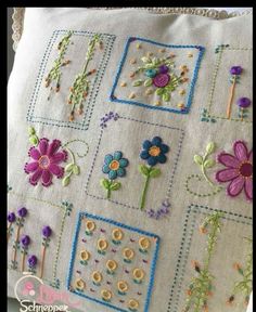 a white pillow with embroidered flowers on it