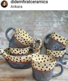 four ceramic cups and saucers with polka dots on them