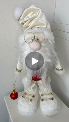 a white stuffed animal with glasses and a santa hat on it's head sitting on top of a shelf