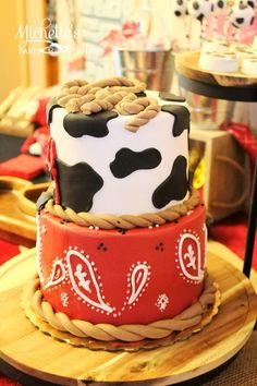 three tiered cake decorated with black and white cow print