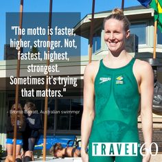 a woman standing in front of a swimming pool wearing a green swim suit and smiling at the camera