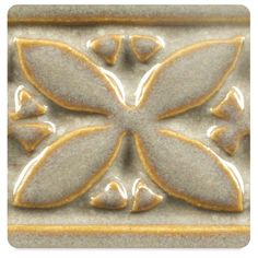 a close up of a decorative tile with flowers on it's center and leaves in the middle