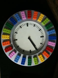 a clock made out of legos in the shape of a rainbow wheel with numbers on each side