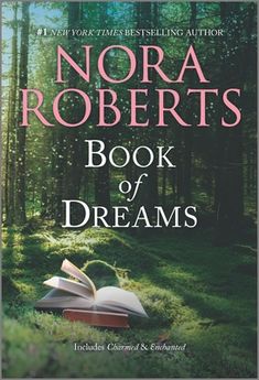 the book of dreams by nora roberts is shown in front of trees and grass