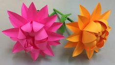 two origami flowers sitting next to each other