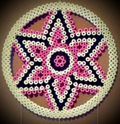 a circular beaded decoration with pink and black beads