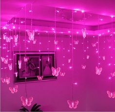 pink lights hanging from the ceiling in a room with butterflies on it and a mirror