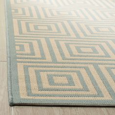 a light blue and beige rug on the floor with white lines in the middle that are interlocked