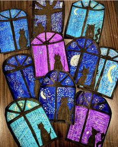 stained glass windows with cats and moon in the night sky, on top of a wooden table