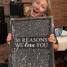 a woman holding up a sign that says 50 reasons we love you