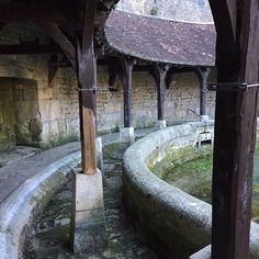 an old building with stone walls and water in the courtyard, next to a fountain