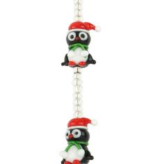 two black and white cats wearing santa hats on a keychain with a red hat