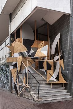 an art installation on the side of a building with stairs leading up to it's entrance