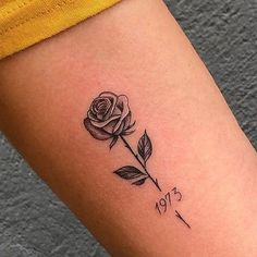 a small rose tattoo on the arm