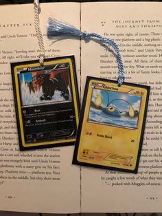 an open book with two pokemon cards attached to it's cover and some string