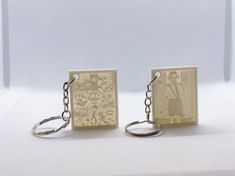 two keychains with pictures on them sitting next to each other in front of a white background