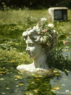 there is a statue in the water with flowers on her head