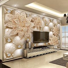 the living room is decorated in white and gold colors with large flowers on the wall