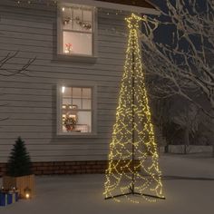 a lighted christmas tree in front of a house