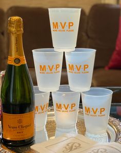 a table topped with glasses and a bottle of wine on top of a metal tray